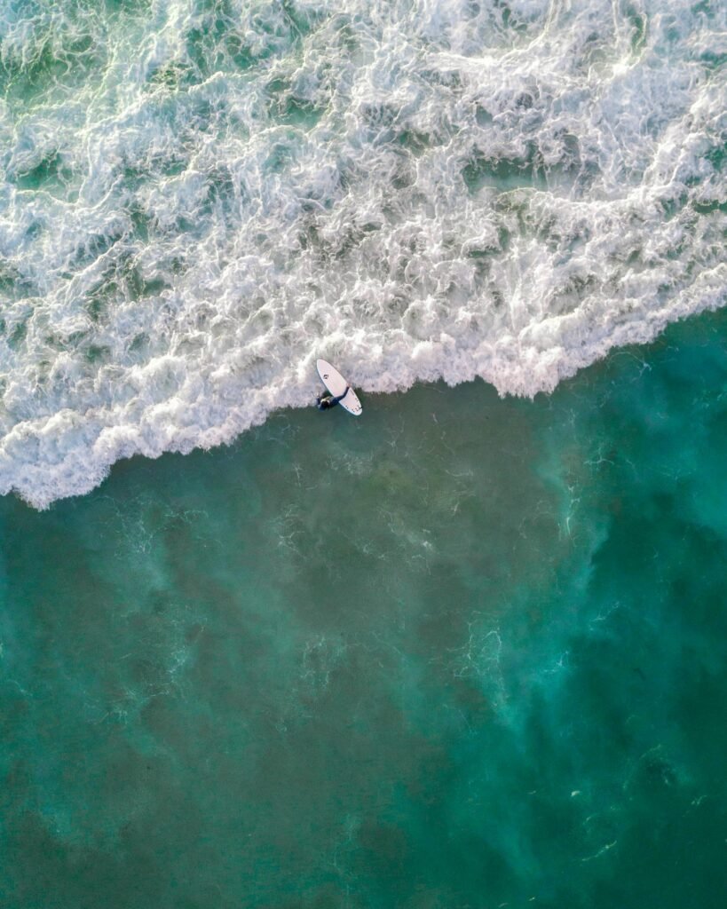 Captivating aerial shot of a surfer riding waves at Bondi Beach, Australia.